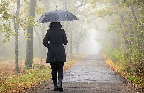 带着黑色雨伞雾森林的女人图片