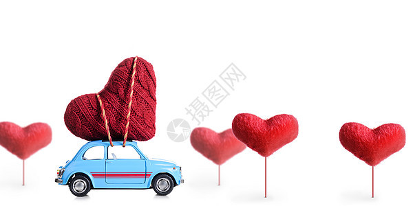 蓝色复古玩具汽车白色背景下为情人节传递工艺之心图片