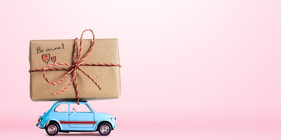 蓝色复古玩具汽车送礼品盒与的标题情人节粉红色背景图片