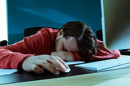精疲力竭的商人睡觉疲惫的商人用电脑睡办公桌前图片
