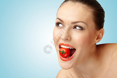 幅创意的肖像,位美丽的女孩她的牙齿里个樱桃番茄图片