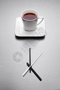 个白色的杯子,极简主义的时钟上装满了茶图片