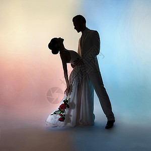 艺术时尚工作室照片的新婚夫妇剪影新郎新娘的颜色背景艺术婚礼风格流动的衣服新郎新娘的舞蹈图片