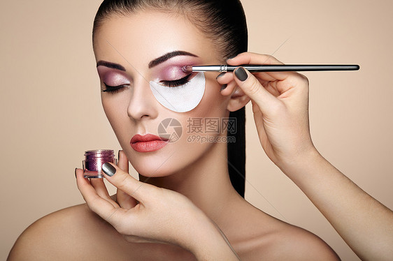 化妆师应用眼影漂亮的女人脸完美的妆容化妆细节美丽的女孩完美的皮肤指甲指甲图片