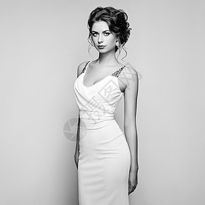 穿着优雅白色连衣裙的美丽女人的时尚肖像着优雅发型珠宝的女孩黑白相间图片