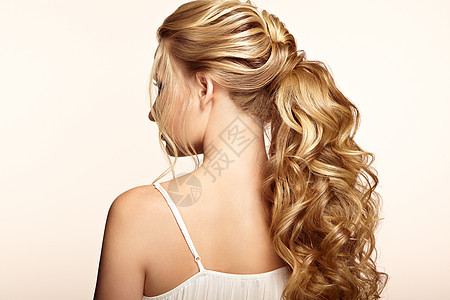 头又长又亮的卷发的金发女孩漂亮的模特,留着卷曲的发型护理美容美发产品头发的护理美丽图片
