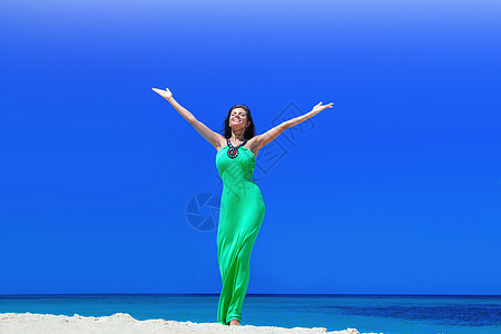海滩上的快乐女人快乐微笑的女人用举的手海滩上享受假期图片