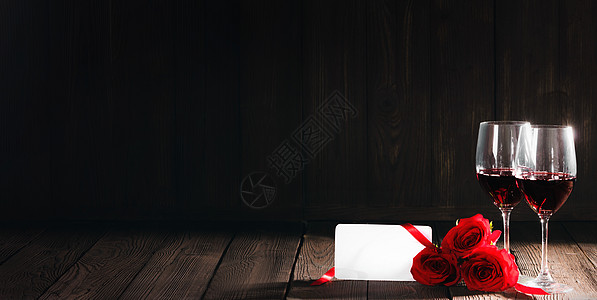 两杯红酒,红玫瑰木制背景上的空白卡图片