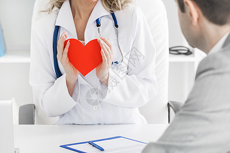 医生向病人展示心脏医生向病人展示红纸心脏,心脏治疗咨询图片