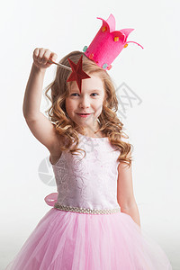 小仙女带着魔杖小仙女穿着粉红色的衣服皇冠,用魔杖施了魔法,孤立白色的背景上图片