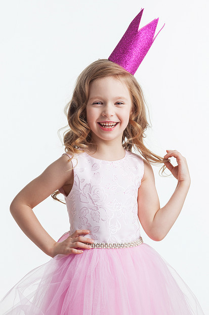 快乐的小公主女孩快乐的小公主女孩穿着粉红色的衣服,皇冠被隔离白色的背景上图片