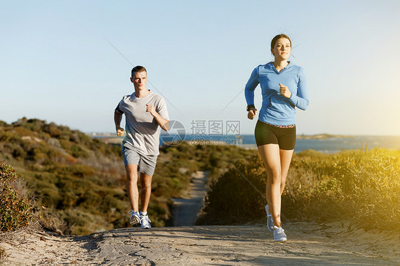 运动跑步者海滩上慢跑,她的搭档锻炼适合女健身模式慢跑沿海洋与她的伴侣图片