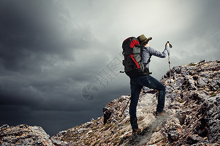 山顶上的轻游客轻的登山者站岩石上的形象图片