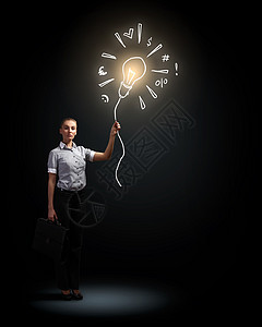 吸引力的女商人黑暗背景灯泡下吸引力的女商人的形象图片