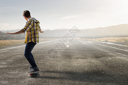 男孩骑滑板活跃的家伙骑滑板沥青路上图片