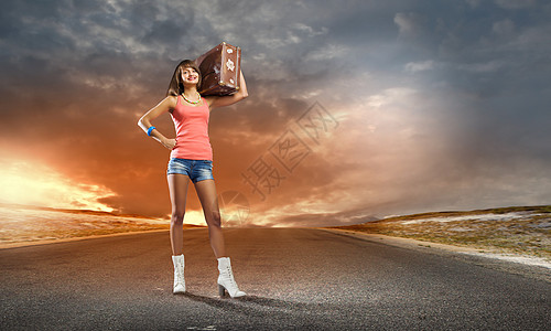 路边吃东西自动启动旅行轻漂亮的女游客,肩上扛着手提箱背景