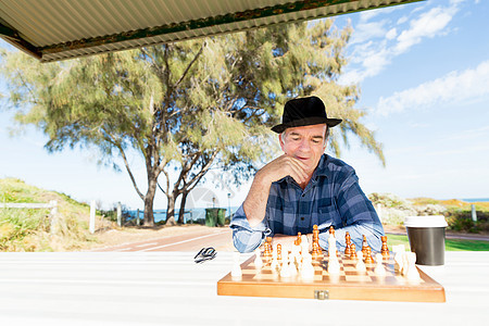 老人坐户外下棋思考国际象棋策略图片