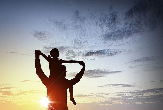 们幸福的家庭父亲小女儿日落背景上的剪影图片