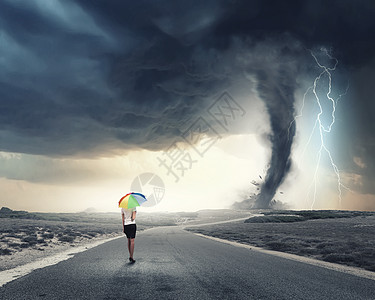 带彩虹伞的女人轻漂亮的女商人带着彩虹五颜六色的雨伞暴风雨中行走图片