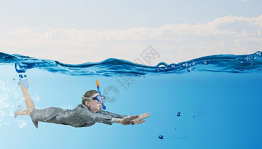 水下的女人穿着西装潜水具的轻女商人水下游泳图片
