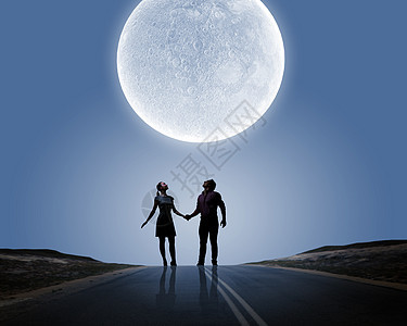 浪漫的站月光下的轻浪漫夫妇的剪影图片