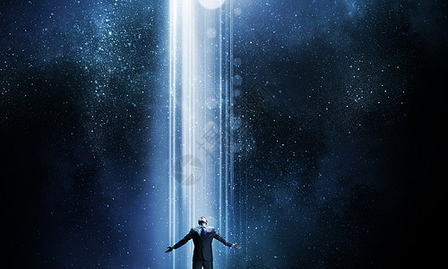 黑暗中的一道曙光图片鉴于成功商人双手张开,站传来的光中背景