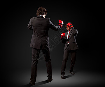 两个轻的商人拳击两个轻的商人拳击再次暴露了黑暗的背景拼贴图片