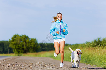 户外跑步轻健康的女孩她的狗户外跑步图片