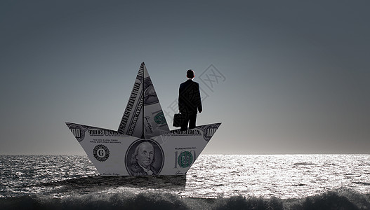商人用美元钞票的船成功的商人金融海洋中乘船航行图片