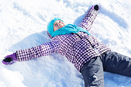 冬天的乐趣快乐的孩子躺冬天公园的雪地上图片