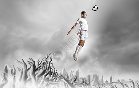 足球迷足球运动员跳跃中踢球,由球迷支持图片