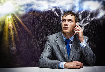 商业挑战轻沮丧的商人雨中用手机说话图片