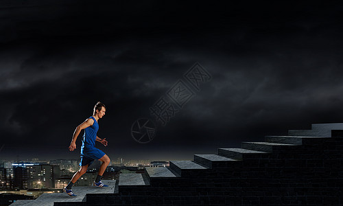 穿着蓝色运动服的跑步者穿着黑色背景全速前进图片