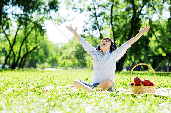 夏天公园里的小快乐男孩戴着耳机大自然的声音图片