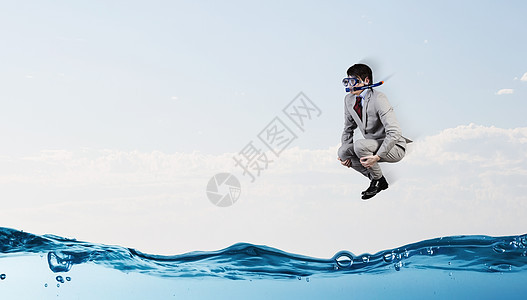 潜水商人穿着西装潜水具的轻商人水里跳跃图片