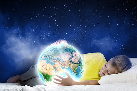 晚上梦可爱的男孩睡床上抱着地球图片