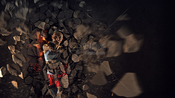 轻的拳击手女人轻的拳击手女人用踢打破混凝土墙图片