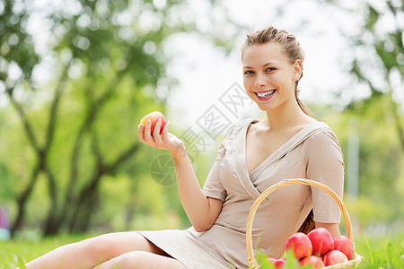 带苹果的女孩夏天公园里带着苹果的轻漂亮女人背景图片