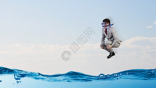 潜水商人穿着西装潜水具的轻商人水里跳跃图片