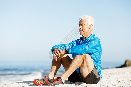 穿着运动服的男人坐海滩上运动中的男人穿着独自坐海滩上休息分钟图片