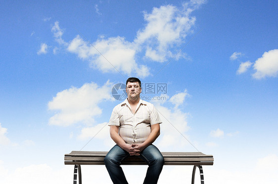 胖子坐长凳上看着远方胖子图片