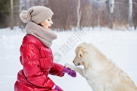 她最好的朋友冬天公园里带着拉布拉多狗散步的女孩图片