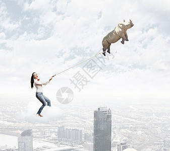 犀牛铅上轻的女人穿着休闲装,犀牛天空中飞翔图片