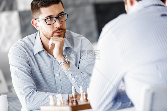 两个轻人下棋的肖像两个轻人办公室下棋的肖像图片