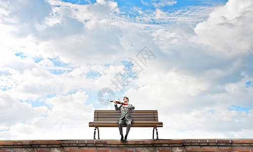 商人拉小提琴穿着西装的轻人坐长凳上拉小提琴图片