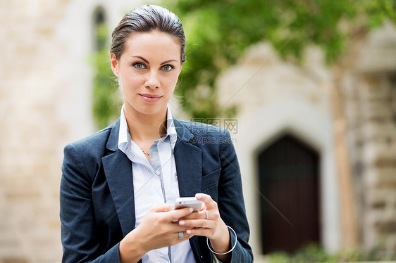 商业女人户外微笑的肖像带手机的轻商务女户外肖像图片