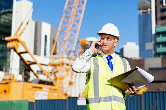 建筑工地的工程师建设者工程师建筑工人施工场景穿着安全背心记事本图片