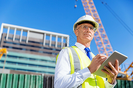 建筑工地的工程师建设者工程师建筑工人施工场景穿着安全背心记事本图片