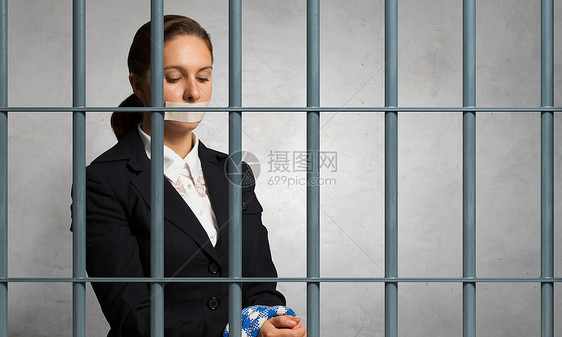 释放无罪的被告轻的女商人,嘴上戴着胶带,双手疲惫图片