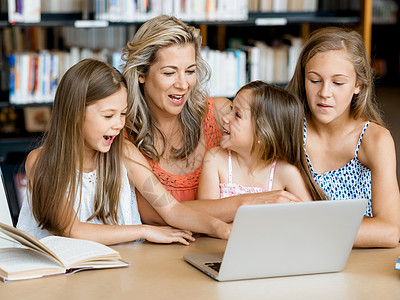 小女孩他们的妈妈图书馆里着笔记本电脑图书馆的技术乐趣图片